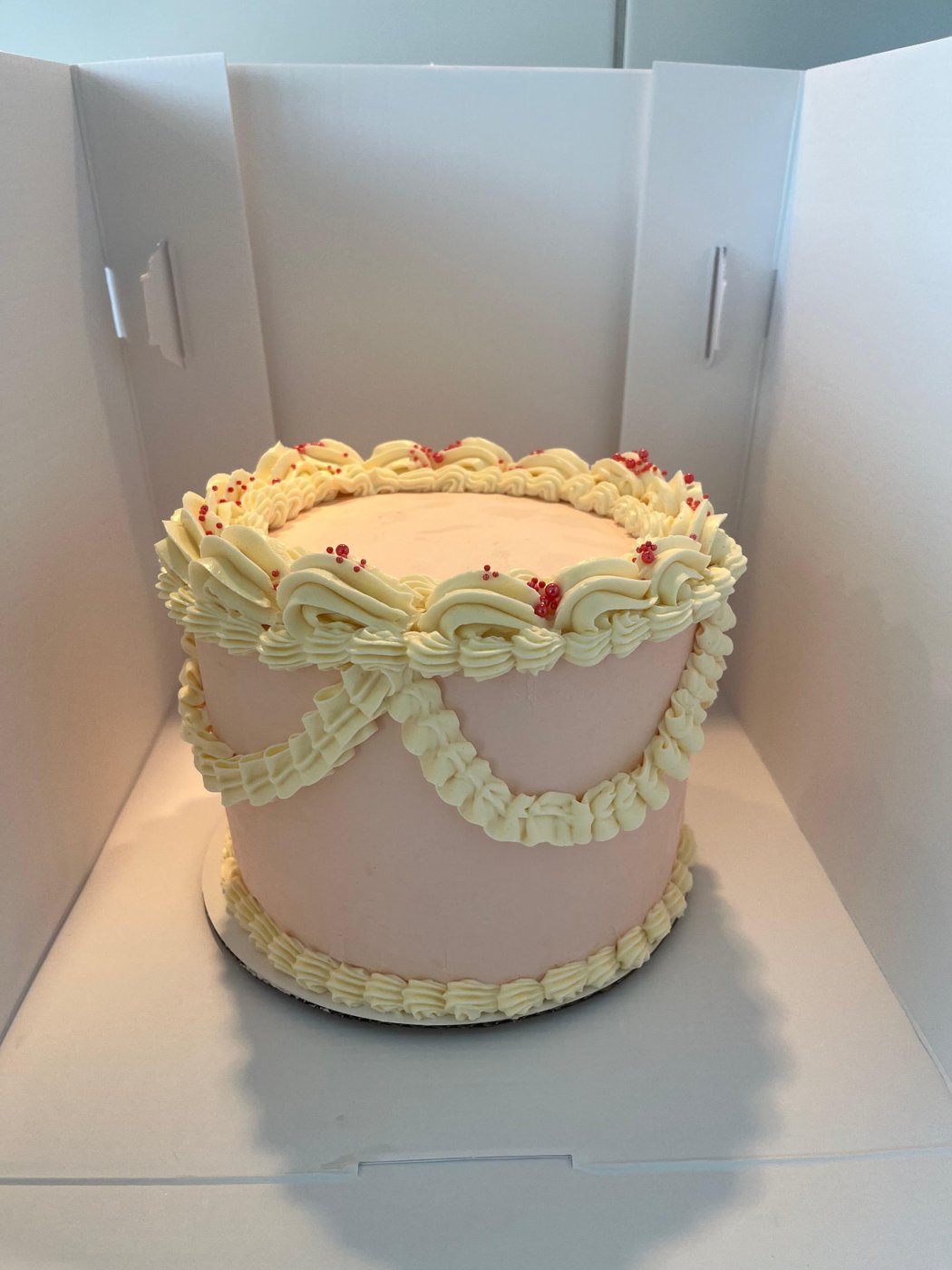 Grand gâteau rose style vintage avec drapés à la crème